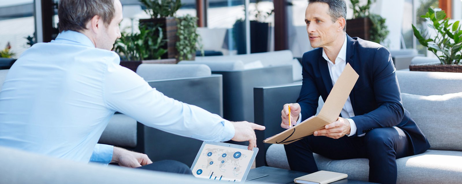 Pleasant smart businessman pointing at the folder